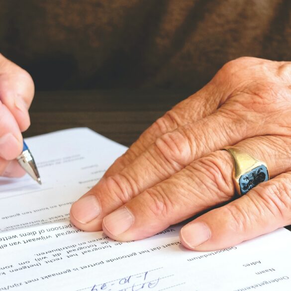 Photo of an elderly person signing a contract
