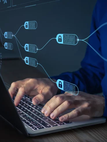 Photo of a man typing on a laptop with an overlay image that looks like blocks inside a distributed ledger