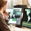 Photo of a man looking at a computer screen with a map of the world, representing a multinational outlook.