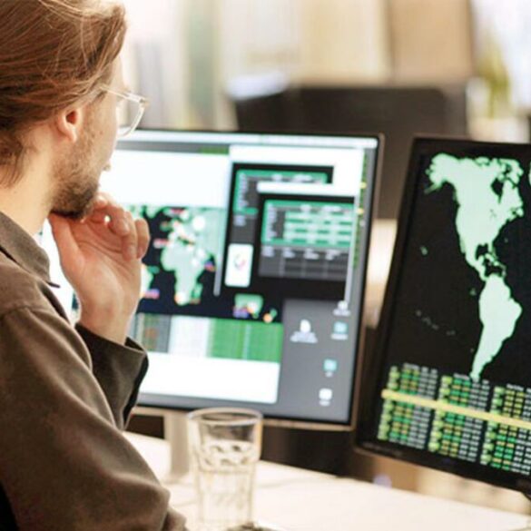 Photo of a man looking at a computer screen with a map of the world, representing a multinational outlook.