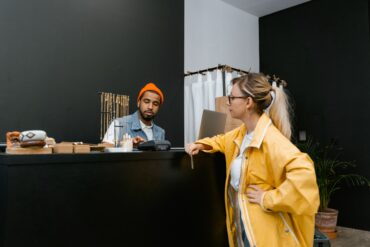 Photo of a woman in a shop making a payment at the counter using her credit card