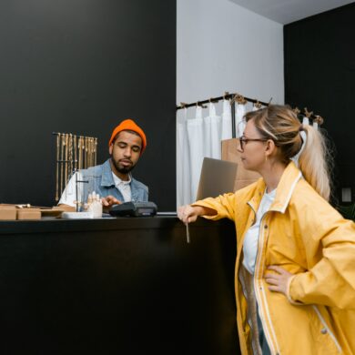 Photo of a woman in a shop making a payment at the counter using her credit card