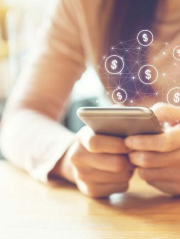 Photo of a woman holding a smartphone with a designed overlay of dollar signs floating out of it