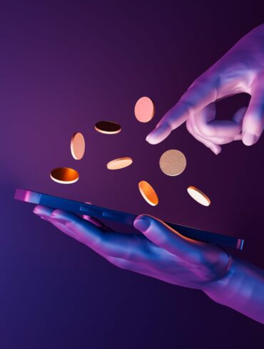 Hands holding a smartphone with coins popping out of the screen (animated)