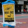 Poster in a city street that writes "break free from fossil fuels."