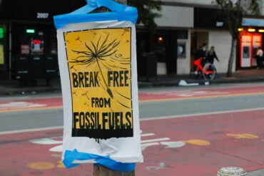 Poster in a city street that writes "break free from fossil fuels."
