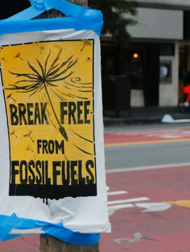 Poster in a city street that writes "break free from fossil fuels."