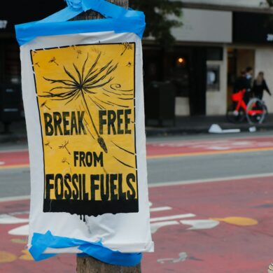 Poster in a city street that writes "break free from fossil fuels."