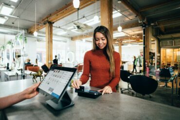 Photo of a woman making a payment during checkout at a physical retail store