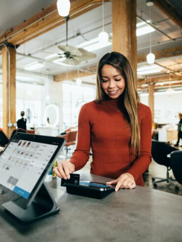 Photo of a woman making a payment during checkout at a physical retail store