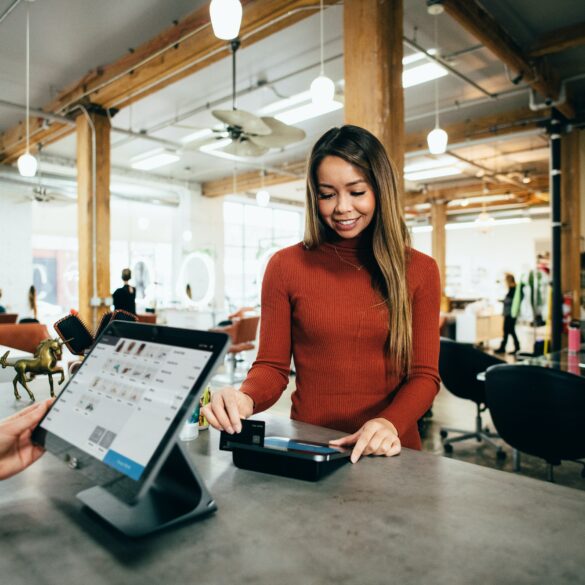 Photo of a woman making a payment during checkout at a physical retail store