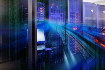 Photo of a server room with a blue coloured technological overlay swooshing across