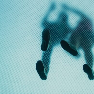 Two blurred people's footsteps from underneath a see-through walkpath.