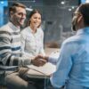 Photo of a couple in a corporate office, with the two men shaking hands.