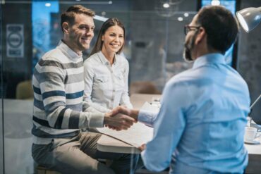 Photo of a couple in a corporate office, with the two men shaking hands.