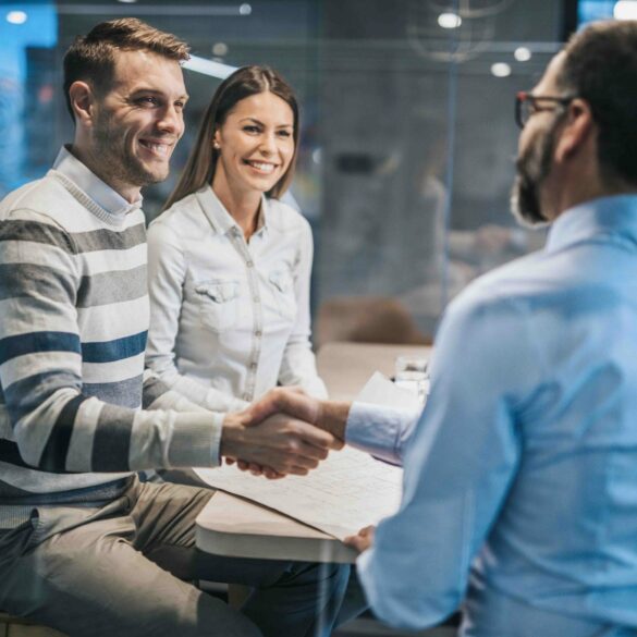 Photo of a couple in a corporate office, with the two men shaking hands.