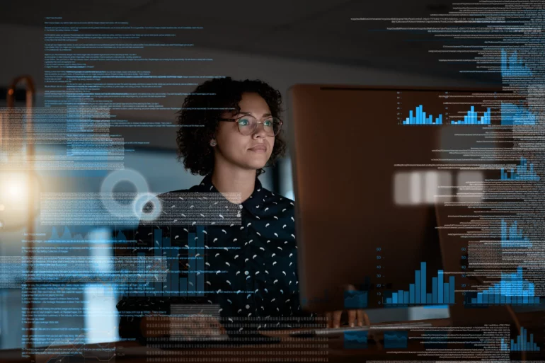 Photo of a woman looking at a laptop with an overlay in the image of data