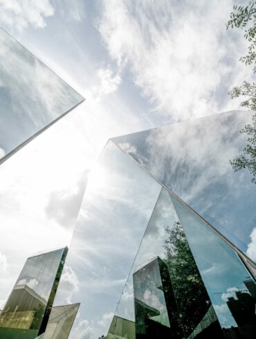Sustainable finance, image of corporate building with reflections of the sun and the surrounding greenery