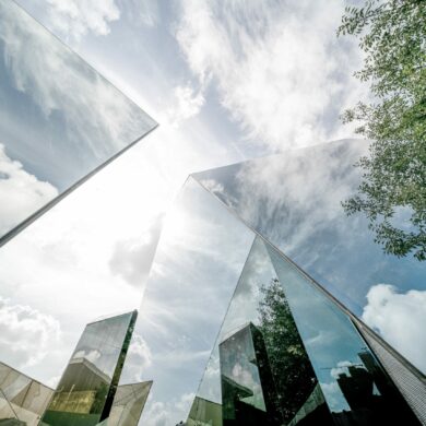 Sustainable finance, image of corporate building with reflections of the sun and the surrounding greenery