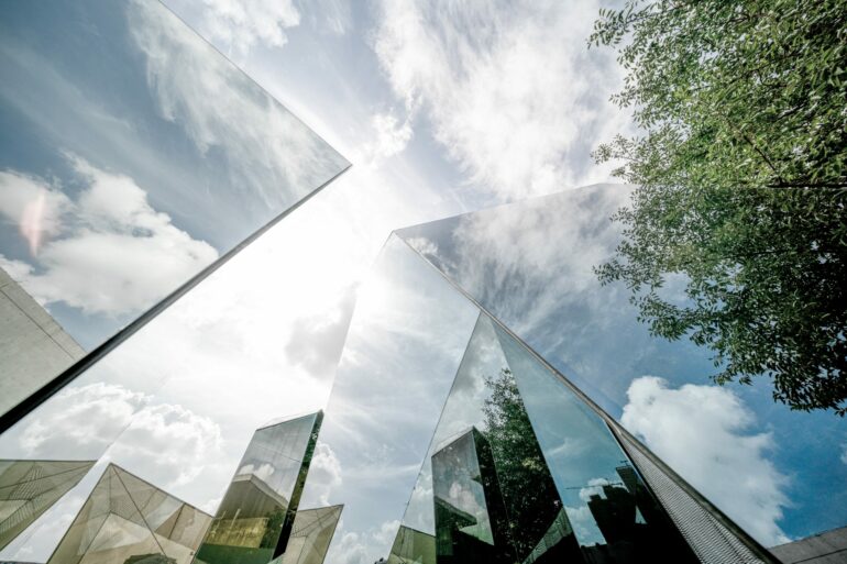 Sustainable finance, image of corporate building with reflections of the sun and the surrounding greenery