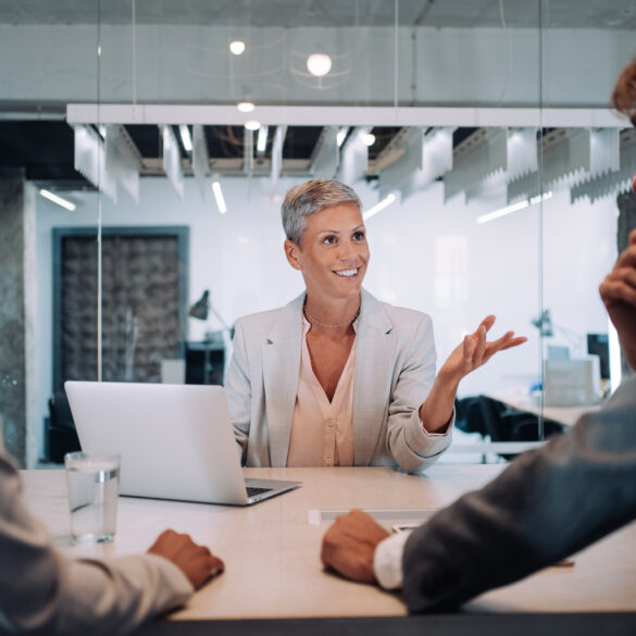 A couple visiting a corporate person for something business related in a commercial office setting that looks like a bank