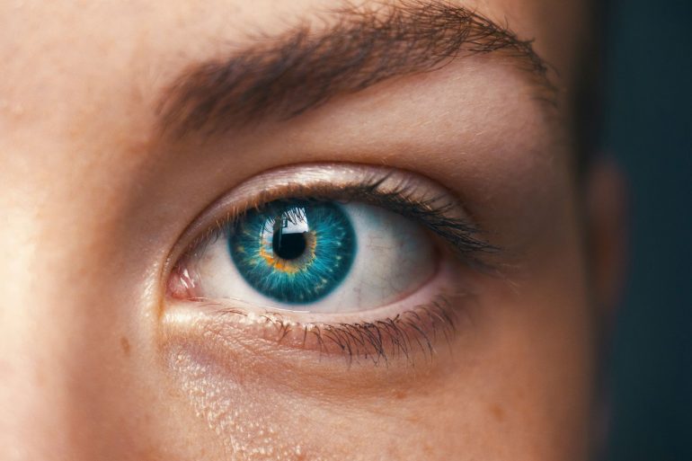 human eye with mixed colours between blue and yellow, looking slightly artificial